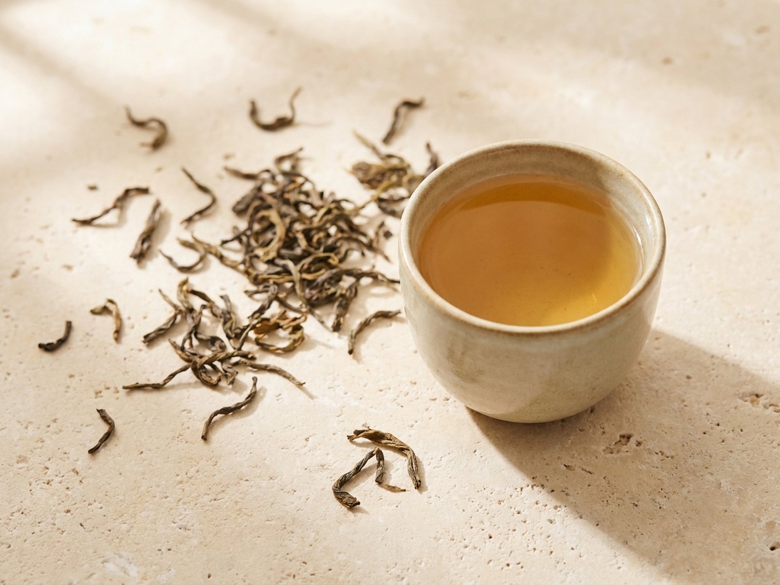 Loose-leaf tea photographed from above, an editorial composition of delicate whole dry leaves
